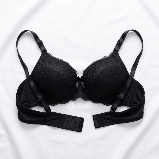 Black wireless bra with adjustable straps and a matching underband, laid flat on a white fabric background.