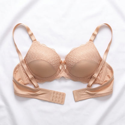 A beige wireless underwire bra with lace cups, adjustable shoulder straps, and a matching underband, laid flat on a white fabric background.