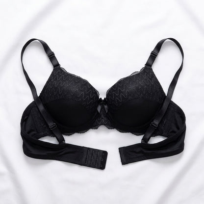 Black wireless bra with adjustable straps and a matching underband, laid flat on a white fabric background.