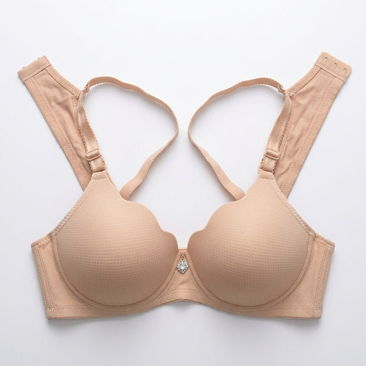 A beige wireless underwire bra with a subtle textured cup surface, adjustable shoulder straps, and a small rhinestone embellishment at the center, laid flat on a light gray background.